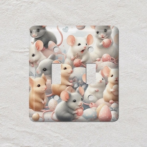 May include: A light switch cover with a whimsical design. It features numerous mice in shades of grey, white, and tan. The mice are surrounded by pastel-coloured eggs and other decorative elements, creating a charming and playful aesthetic.