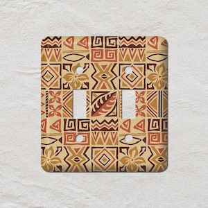 May include: A double light switch cover featuring a repeating geometric pattern in shades of brown, tan, and orange. The design incorporates squares, triangles, and floral motifs, giving a textured look.