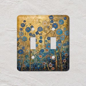 May include: A decorative double light switch cover featuring a floral design. The artwork showcases blue flowers with gold accents against a golden and teal background. The design has an artistic, painterly style.