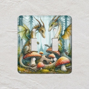 May include: A decorative light switch cover with a watercolour illustration of two dragons. The dragons are set against a forest backdrop with mushrooms. The colour scheme includes greens, oranges, and blues.