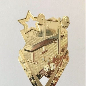 May include: Gold trophy with a weightlifting design, a purple base with a gold trim, and a white base with a gold plate that says "YOUR WORDS HERE!"
