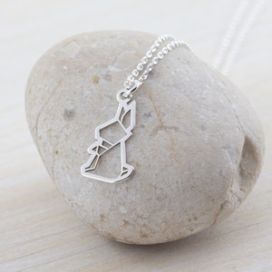 May include: A silver necklace with a delicate origami rabbit pendant. The pendant is made of thin metal and has a simple, elegant design.