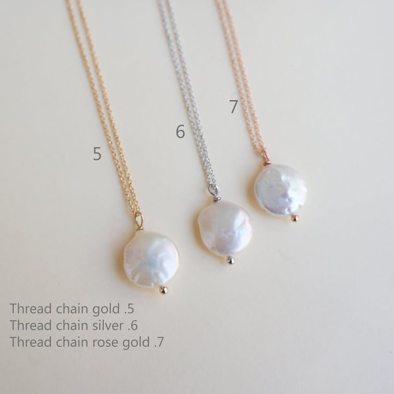 May include: Three delicate necklaces with pearl pendants. The necklaces are available in gold, silver, and rose gold. The pearl pendants are all the same size and shape, and they have a slightly irregular, natural look.