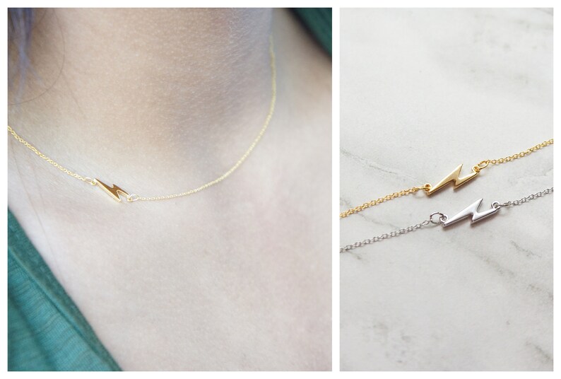May include: A delicate gold necklace featuring a lightning bolt pendant. The necklace is shown on a person's neck, and a second image shows the necklace in gold and silver. The chain is thin and the lightning bolt is small.