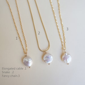 May include: Three gold necklaces with pearl pendants. The necklaces are labeled 1, 2, and 3. The necklace labeled 1 has an elongated cable chain. The necklace labeled 2 has a snake chain. The necklace labeled 3 has a fancy chain.