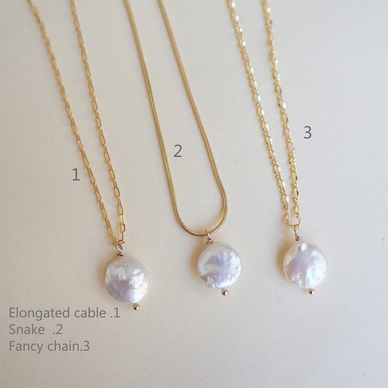 May include: Three gold necklaces with pearl pendants. The necklaces are labeled 1, 2, and 3. The necklace labeled 1 has an elongated cable chain. The necklace labeled 2 has a snake chain. The necklace labeled 3 has a fancy chain.