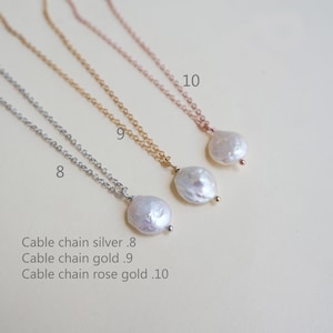 May include: Three delicate necklaces with pearl pendants. The necklaces are silver, gold, and rose gold. The pearls are white and have an irregular shape. The necklaces are labeled 8, 9, and 10.