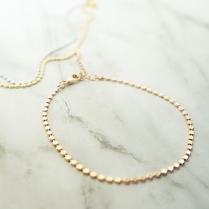 Puede incluir: Un delicado brazalete de cadena dorada con un dise&ntilde;o de eslabones cuadrados. El brazalete est&aacute; hecho de una cadena fina y tiene un aspecto simple y elegante.