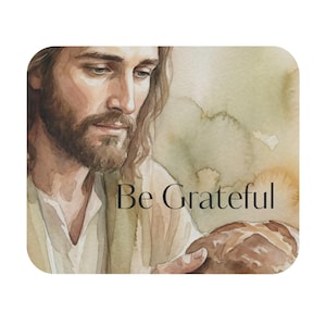 Pode incluir: Ilustração em aquarela com um retrato de um homem com cabelo comprido e barba, segurando pão. O texto "Be Grateful" está escrito em uma fonte de script. O fundo tem lavagens suaves em aquarela em tons de verde e bege.
