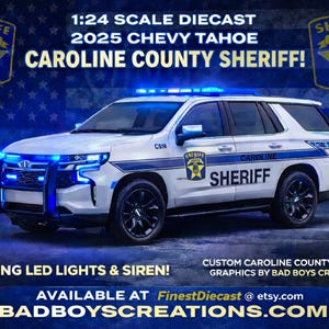 May include: A 1:24 scale diecast model of a 2025 Chevy Tahoe, featuring Caroline County Sheriff markings. The white SUV has blue emergency lights and black wheels. Text includes "Working LED Lights & Siren!" and "BADBOYSCREATIONS.COM".