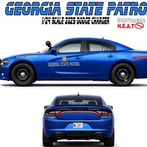 Op de afbeelding: Een blauw 1/24 schaalmodel van een 2023 Dodge Charger, met het logo en de tekst van de Georgia State Patrol. Het modelauto heeft zwarte wielen en een zwarte pushbar. De achteraanzicht van de auto is ook afgebeeld.