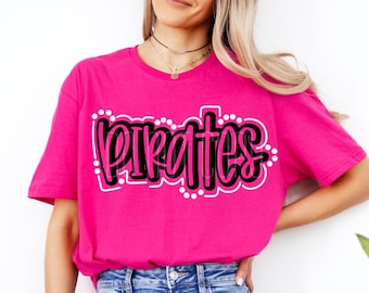 May include: A pink t-shirt with the word "Pirates" written in black and white lettering with white polka dots around the word.