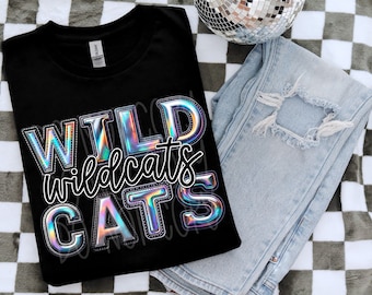 Peut inclure: T-shirt noir avec un motif holographique qui dit "WILD wildcats CATS".