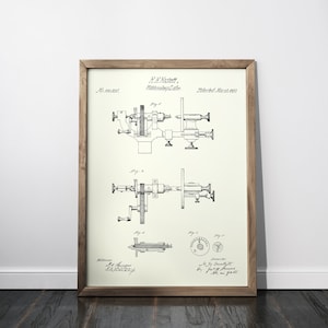 Puede incluir: Plano vintage enmarcado de una máquina, con dibujos técnicos detallados en tinta negra sobre fondo crema. El marco de madera añade un toque clásico. La impresión incluye texto y diagramas.