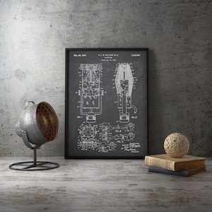 May include: Black framed vintage microphone patent print. The print is displayed on a distressed wooden surface, with a metal spotlight and decorative sphere. The patent date is May 20, 1941.
