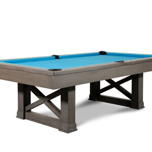 May include: A gray wooden pool table with a blue felt top and a rustic X-shaped base.