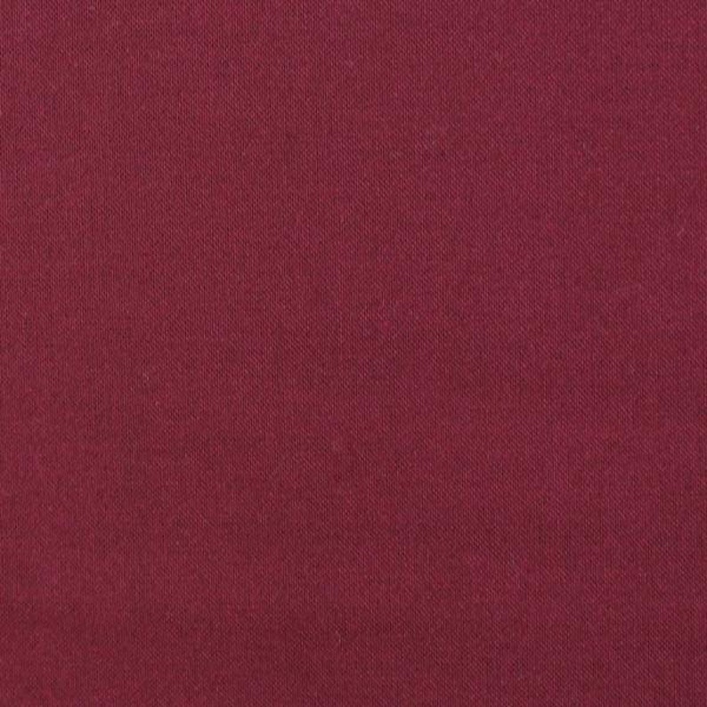 Puede incluir: Primer plano de una tela burdeos lisa. El material tiene una textura sutil con l&iacute;neas verticales, creando una sensaci&oacute;n de profundidad. El color es un tono rojo intenso y rico, adecuado para diversas aplicaciones textiles.