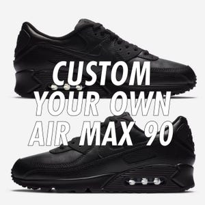 Puede incluir: Dos zapatillas Air Max 90 negras. Los zapatos tienen un dise&ntilde;o texturizado y c&aacute;maras de aire visibles en las suelas. El texto blanco superpuesto dice "CUSTOM YOUR OWN AIR MAX 90".