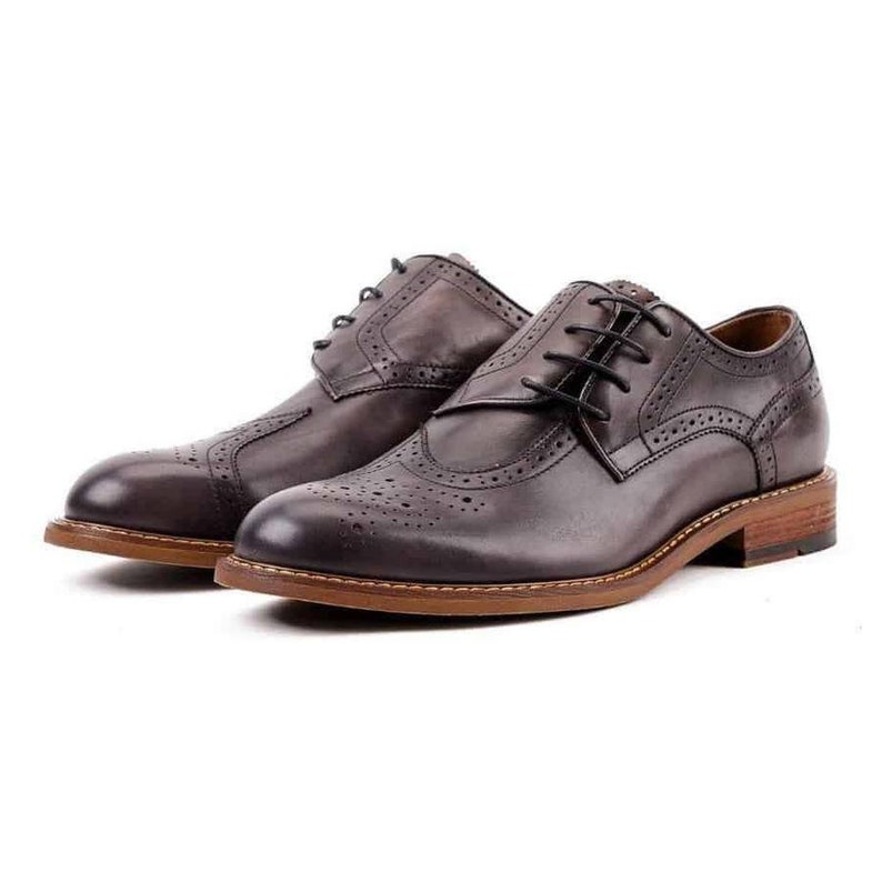 May include: A pair of brown leather brogue shoes with lace-up closures. The shoes have a wingtip design and a perforated pattern.