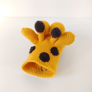 May include: A crocheted giraffe toy with a yellow body and black spots. The giraffe has a long neck and a small head with black eyes.