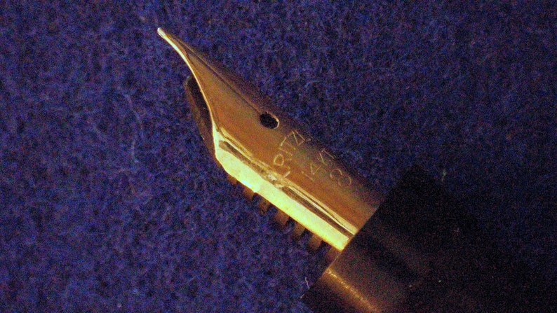 May include: Gold-toned fountain pen nib with the inscription "RITZ 14K 585" on the side.
