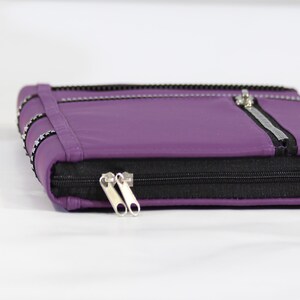 May include: A purple leather zippered pouch with a silver zipper pull and a black zipper.
