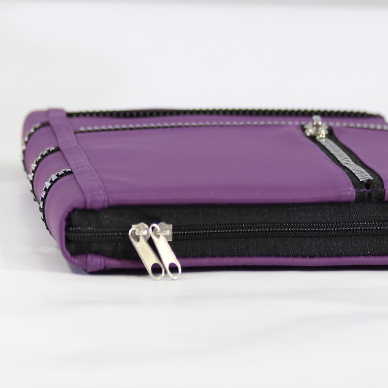 May include: A purple leather zippered pouch with a silver zipper pull and a black zipper.