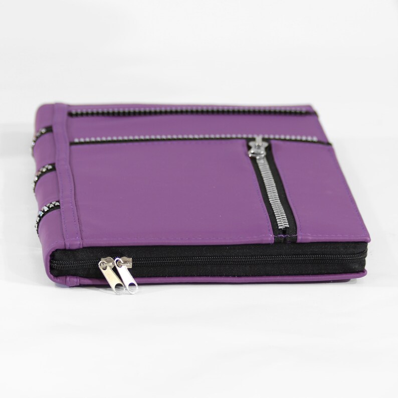 May include: A purple leather zippered pouch with silver zippers and a black zipper pull.
