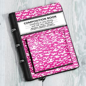 May include: A composition book cover in bright pink and white camouflage pattern with black trim and zipper details. The white label reads: COMPOSITION BOOK, Creativity is very messy, and I'm very creative, WIDE RULED, 100 SHEETS, 200 PAGES, 9.75 INCH X 7.5 INCH.