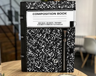 May include: A black and white composition book cover featuring a classic speckled pattern, a white label with the text COMPOSITION BOOK, WIDE RULED, 100 SHEETS, 200 PAGES, 9.75 INCH X 7.5 INCH (24.7 cm X 19.0 cm), and multiple silver metal zippers.