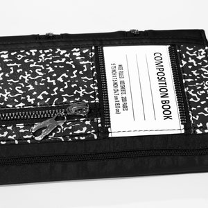 May include: Black composition book with a zipper closure and a white label that reads "COMPOSITION BOOK" and "WIDE RULED. 100 SHEETS. 200 PAGES 9.75 INCH X 7.5 INCH (24.7 cm X 19.0cm)"