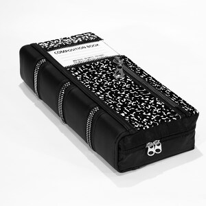 May include: A black zippered pouch shaped like a book with a composition notebook pattern on the front. The pouch has the words "COMPOSITION BOOK" printed on the front.