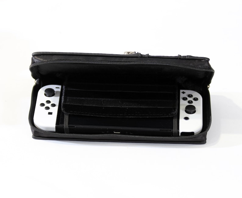 May include: A black zippered carrying case for a Nintendo Switch console. The case is open and the white console is inside with the controllers attached.