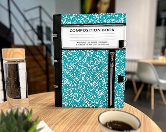 May include: A teal and white speckled composition book cover featuring a black spine with zipper details, a white label with the text COMPOSITION BOOK, WIDE RULED, 100 SHEETS, 200 PAGES, 9.75 INCH X 7.5 INCH, and a vertical silver zipper closure.