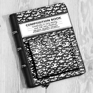 May include: A black and white composition book with a speckled pattern, featuring a front pocket and a label that reads: COMPOSITION BOOK, Creativity is very messy, and I'm very creative, WIDE RULED, 100 SHEETS, 200 PAGES, 9.75 INCH X 7.5 INCH.