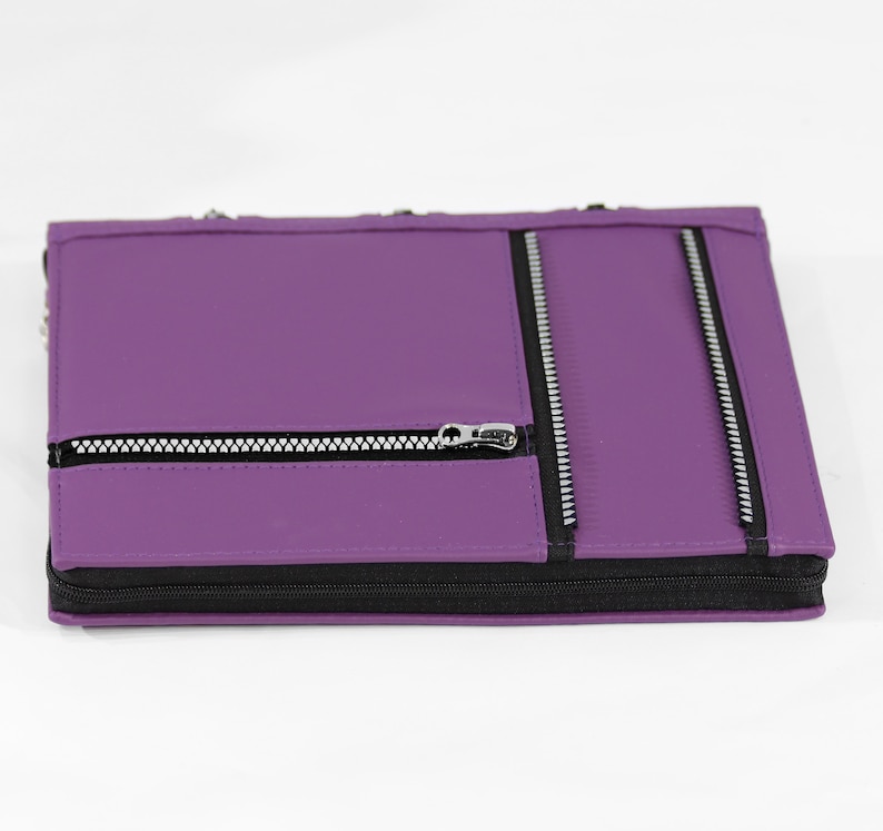 May include: Purple leather zippered notebook with three zippered pockets on the front.