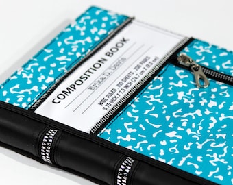 May include: A teal and white speckled composition book cover featuring a black spine with silver accents, a white label area with the text COMPOSITION BOOK, WIDE RULED, 100 SHEETS, 200 PAGES, 9.75 INCH X 7.5 INCH, and a silver metal zipper pull.