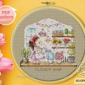 May include: Cross-stitch embroidery depicting a flower shop scene. A girl waters flowers inside a shop with a brick wall. The shop features shelves with sunflowers, cacti, and other plants. The text "FLOWER SHOP" is at the bottom.