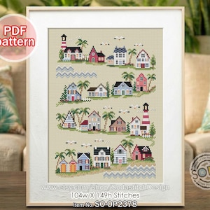 May include: Framed cross-stitch pattern featuring a coastal village scene with colorful houses, palm trees, and a lighthouse. The pattern includes the text "PDF pattern" and the shop's Etsy URL. The design measures 104w x 149h stitches.