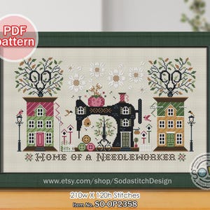 Pode incluir: Padrão de ponto cruz emoldurado em uma moldura verde. O design apresenta uma máquina de costura preta, duas casas e o texto "HOME OF A NEEDLEWORKER". O padrão inclui o texto "PDF pattern" e o URL da loja Etsy.