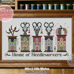 Puede incluir: Patrón de punto de cruz enmarcado en madera. El diseño presenta casas estilizadas con varios elementos decorativos, incluyendo algodón, tijeras y una calabaza. El texto "House of Needleworkers" se muestra debajo. También incluye el texto "PDF pattern".