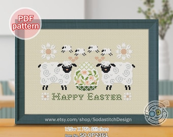 May include: Cross-stitch pattern featuring two sheep flanking a decorated Easter egg, with the words "Happy Easter" below. The design includes floral accents and small sheep. The framed artwork is in a teal frame.