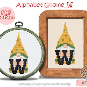 Puede incluir: Patrón de punto de cruz para un gnomo que sostiene la letra W. El gnomo lleva un gorro amarillo con detalles verdes y un atuendo blanco y negro. El patrón está disponible para descargar en PDF. La imagen también incluye el texto "Alphabet Gnome_W" y "SO-W".