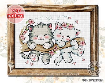 May include: Cross-stitch pattern featuring two cartoon cats on a branch with pink flowers. The cats are gray and white with smiling faces. The framed artwork includes the text "PDF pattern" and the Etsy shop name.