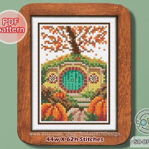 May include: Cross stitch pattern of a hobbit house with a round green door, surrounded by pumpkins and a tree with orange leaves. The pattern is 44 wide by 62 high stitches.