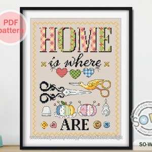 May include: Cross-stitch pattern framed in black, featuring the words "HOME is where ARE." The design includes scissors, heart-shaped motifs, and pincushions. The text "PDF pattern" is in the upper left corner. The Etsy shop URL is at the bottom.