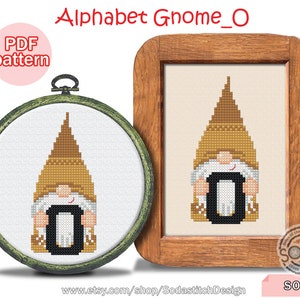 Puede incluir: Un patrón de punto de cruz con un gnomo sosteniendo la letra O. El gnomo lleva un gorro marrón y una camisa blanca. El patrón está enmarcado en un marco de madera. El texto "Alphabet Gnome_O" está en la parte superior de la imagen. El texto "S0-0" está en la parte inferior de la imagen.
