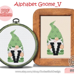 Pode incluir: Um padrão de ponto cruz de um gnomo verde segurando uma letra V. O gnomo está usando um chapéu verde com bolinhas brancas e tem uma barba branca. A letra V é preta. O padrão está em uma moldura de madeira e é rotulado como "Alphabet Gnome_V" e "SO-V".