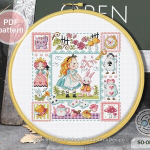 May include: A colorful cross-stitch pattern featuring Alice in Wonderland characters, including Alice, the Mad Hatter, the Queen of Hearts, and the Cheshire Cat. The pattern is framed in a wooden hoop and includes the text "SO-OP3177".