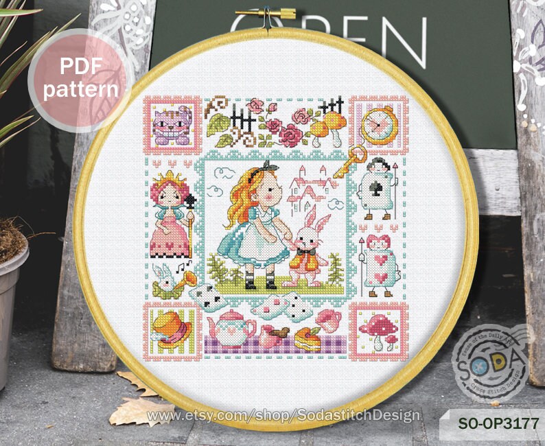 May include: A colorful cross-stitch pattern featuring Alice in Wonderland characters, including Alice, the Mad Hatter, the Queen of Hearts, and the Cheshire Cat. The pattern is framed in a wooden hoop and includes the text "SO-OP3177".